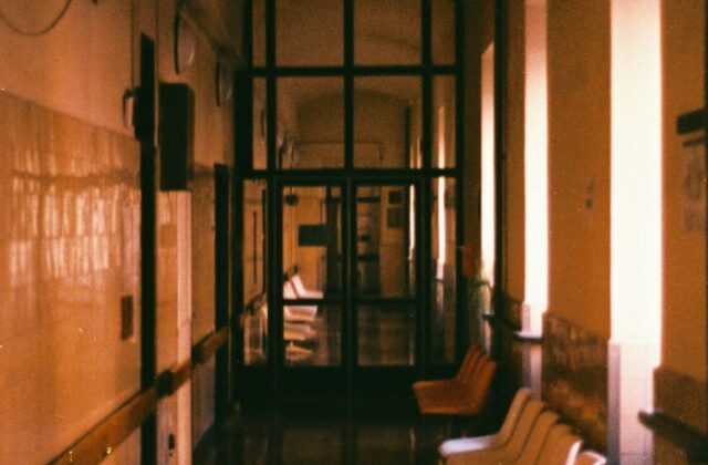 An empty hospital waiting room with rows of chairs and soft daylight