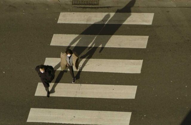 A San Fernando Valley intersection at dusk with headlights passing through the crosswalk