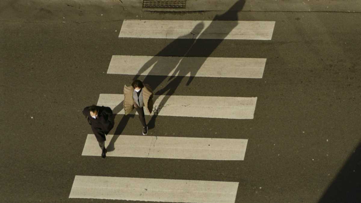 A San Fernando Valley intersection at dusk with headlights passing through the crosswalk