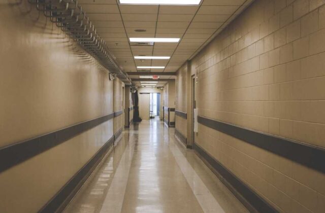 Quiet hospital corridor with a records desk and filing shelves along the wall