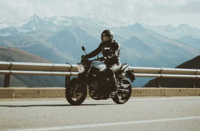 Motorcyclist riding between two lanes of slowed freeway traffic