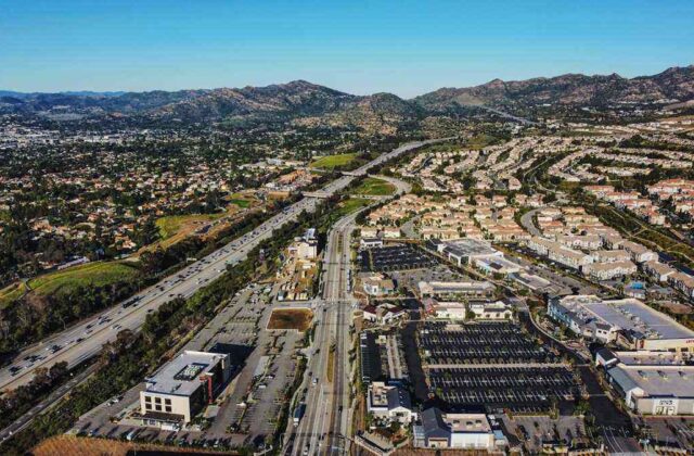 Street in Pacoima with murals, small businesses and the San Gabriel foothills in the background