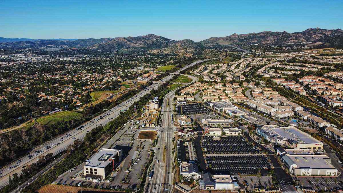 Street in Pacoima with murals, small businesses and the San Gabriel foothills in the background