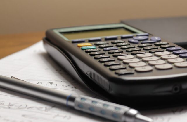 A pen and calculator resting on a document