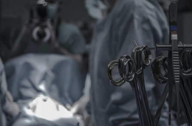 Surgical scissors and instruments laid out near doctors in an operating room