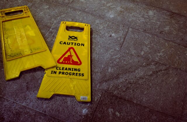 Two yellow caution signs lying knocked over on a stone floor