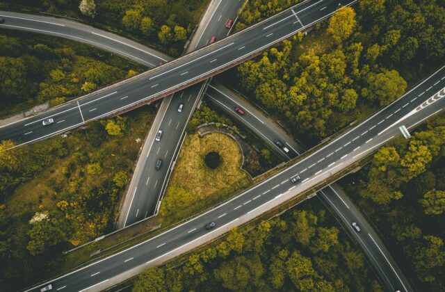 Aerial view of interlocking freeway interchange ramps with cars traveling through