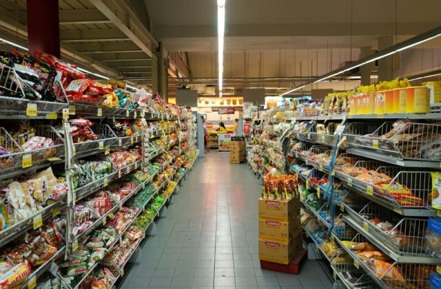 Grocery store aisle with metal shelves stocked with packaged food products